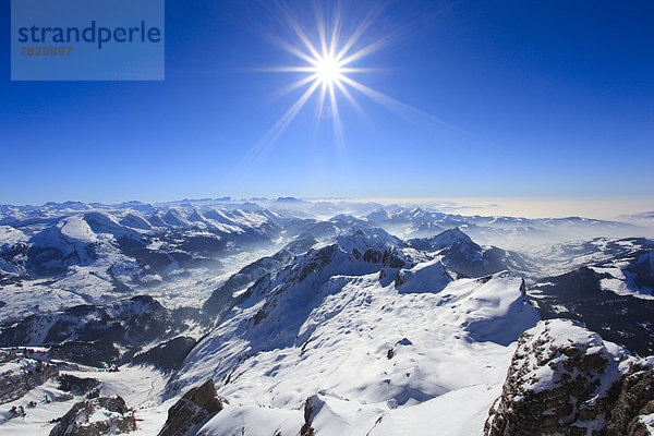 Kälte  Panorama  sternförmig  Europa  Schneedecke  Berg  Winter  Berggipfel  Gipfel  Spitze  Spitzen  Sonnenstrahl  Himmel  Dunst  Schnee  Nebel  Alpen  blau  Ansicht  Sonnenlicht  Westalpen  Bergmassiv  Sonne  schweizerisch  Schweiz