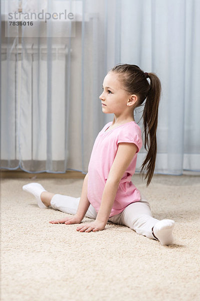 Ballerina Mädchen macht die Spagat in ihrem Schlafzimmer
