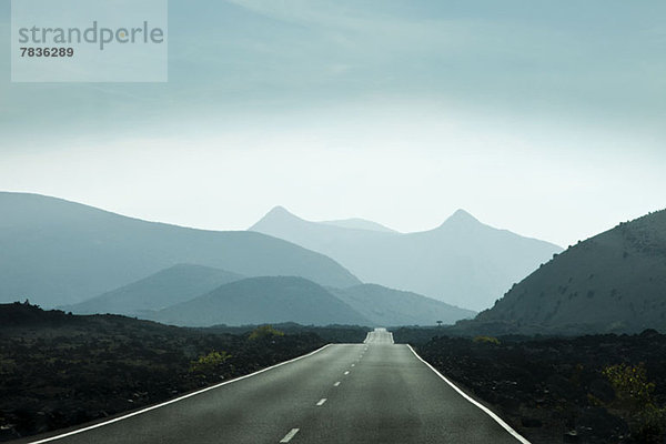 Leere Straße in Richtung Berge auf Lanzarote  Kanarische Inseln  Spanien