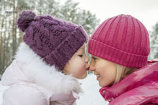 Eine Mutter und Tochter in warmer Kleidung  im Freien  von Angesicht zu Angesicht.