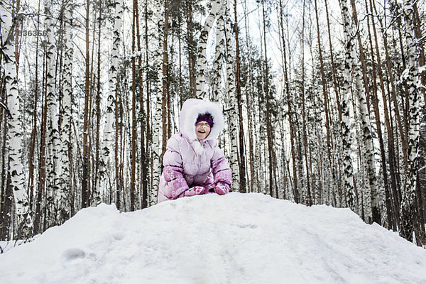 Ein junges Mädchen spielt im Schnee.