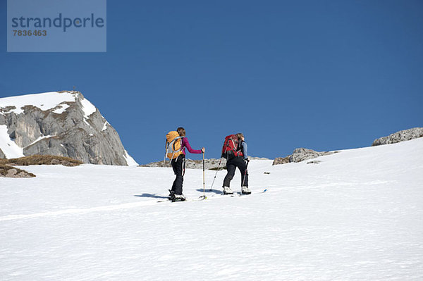 Zwei Skifahrer auf einer verschneiten Anhöhe in den Dolomiten  Südtirol  Italien