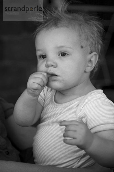 Baby auf Vaters Schoß schaut weg