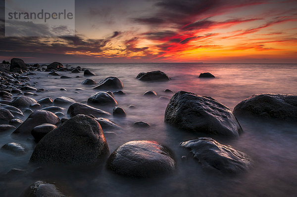 Steine am Strand bei Sonnenuntergang am Meer