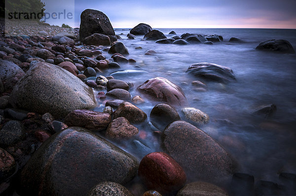 Steine am Strand am Meer  in der Abenddämmerung