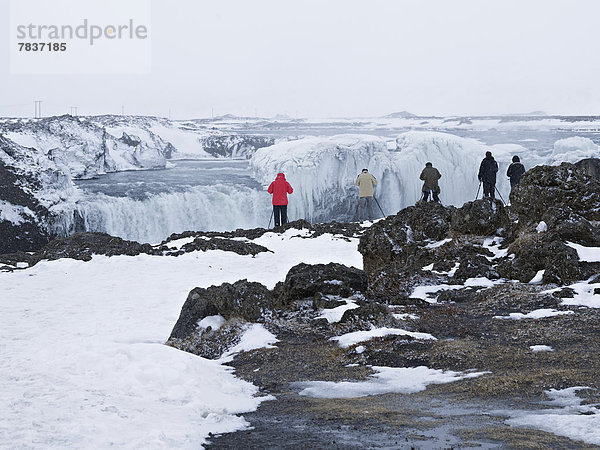 Touristen fotografieren den Godafoss Wasserfall