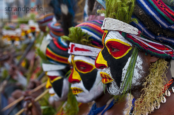 Bunt geschmückte und bemalte Stammesangehörige feiern das traditionelle Sing Sing im Hochland