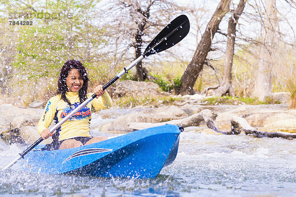 USA  Texas  Junge Frau beim Kajakfahren auf dem Frio River  lächelnd