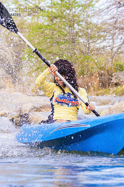 USA  Texas  Junge Frau beim Kajakfahren auf dem Frio River  lächelnd