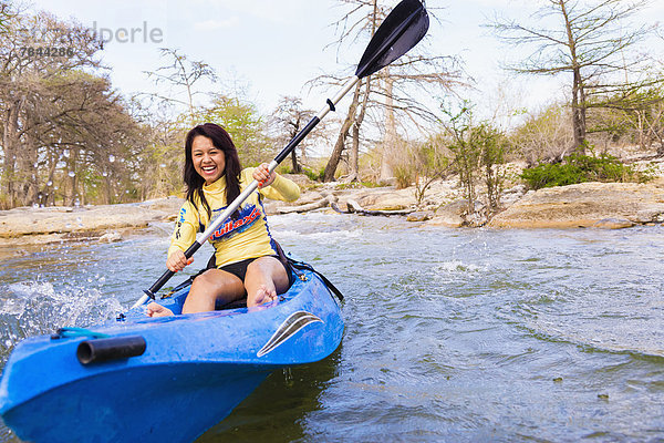 USA  Texas  Junge Frau beim Kajakfahren auf dem Frio River  lächelnd