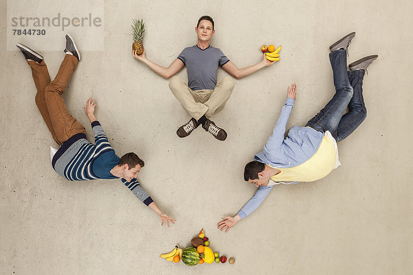 Männer mit auf dem Boden liegendem Essen