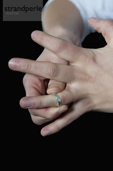 Junge Frau zieht Ring aus dem Finger  Nahaufnahme
