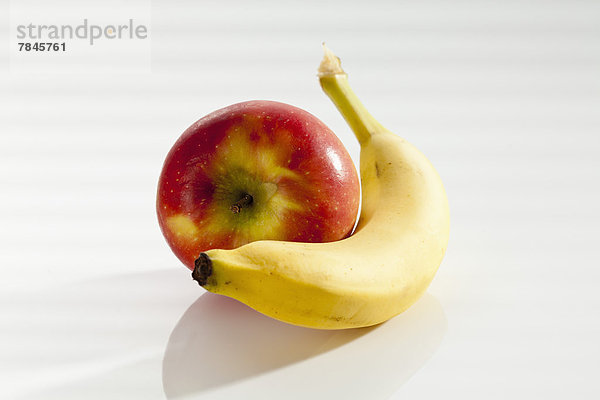 Banane mit Apfel auf weißem Hintergrund  Nahaufnahme
