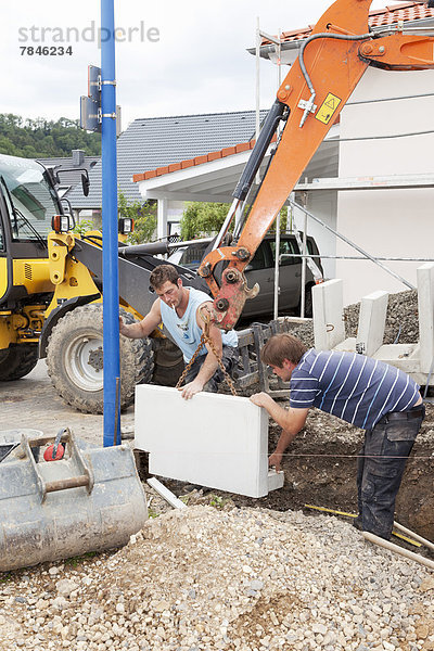 Europe  Germany  Rhineland Palatinate  Men working with corner stones during house building
