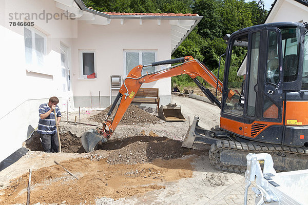 Germany  Rhineland Palatinate  Worker digging soil with excavator