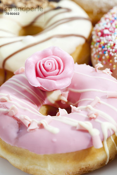 Variety of doughnuts topped with icing and sprinkles  close up