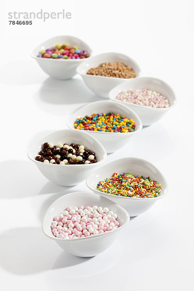 Variety of litter decor in bowls on white background  close up