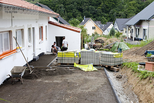 Germany  Rhineland Palatinate  Workers paving stone at house building