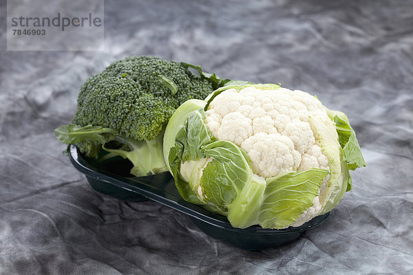 Cauliflower with broccoli on grey background  close up