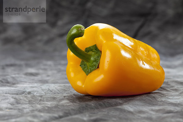 Yellow bell pepper on grey background  close up