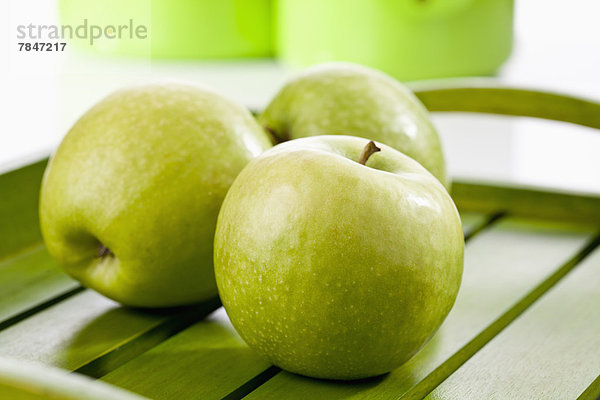 Green apples on wooden tray  close up