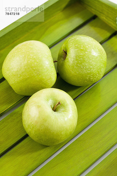 Green apples on wooden tray  close up