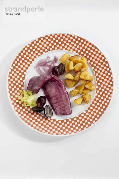 Sherry herring with roasted potatoes  onion and grapes on plate