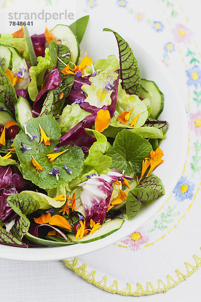 Schüssel mit Salat auf Platzdeckchen  Nahaufnahme