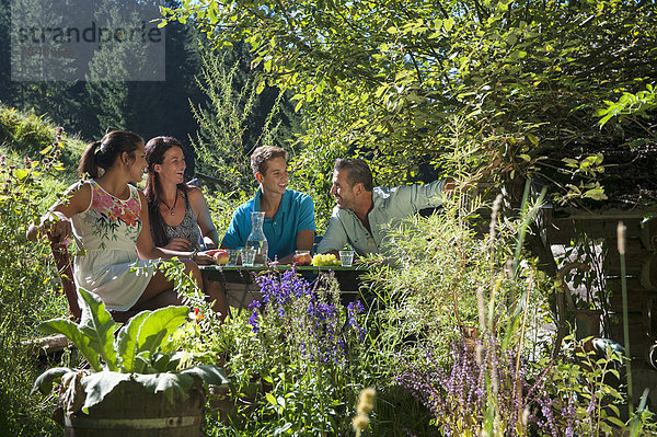 Österreich  Salzburg  Familie im Garten plaudern  lächeln