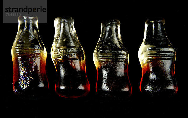 Gummibärchen in Form von Flaschen auf schwarzem Hintergrund  Nahaufnahme