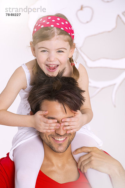 Porträt eines Mädchens auf der Schulter des Vaters  lächelnd