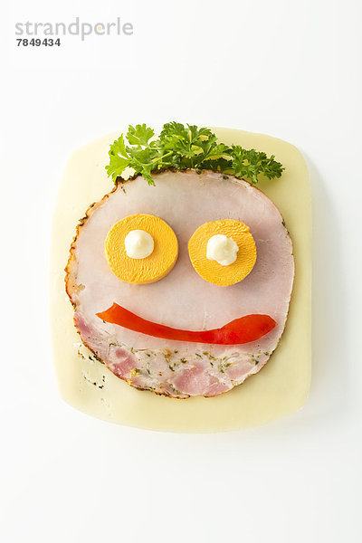 Smiley-Wurst-Sandwich mit Käse und Pfeffer auf weißem Hintergrund