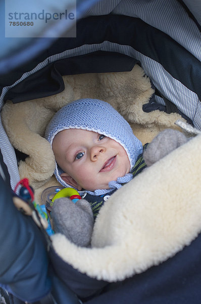 Baby Junge im Kinderbett liegend  lächelnd