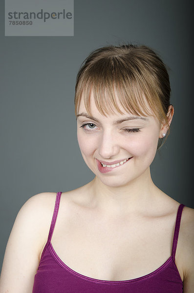 Porträt einer jungen Frau mit Augenzwinkern  Nahaufnahme  Mund