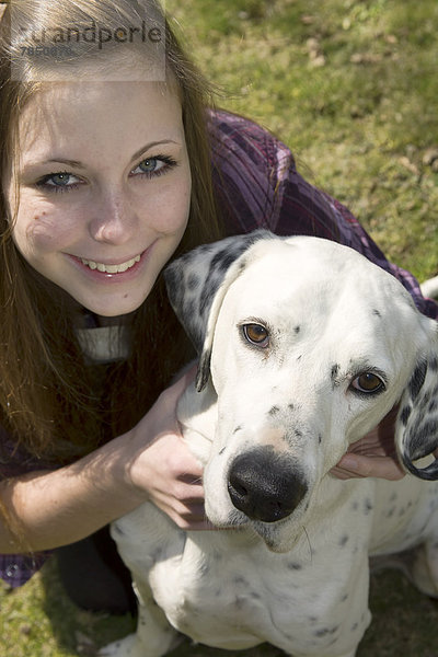 Deutschland  Porträt eines jungen Mädchens mit dalmatinischem Hund  lächelnd