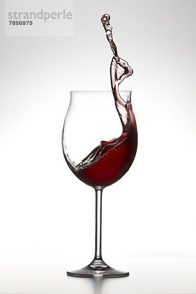 Rotwein im Glas auf weißem Hintergrund