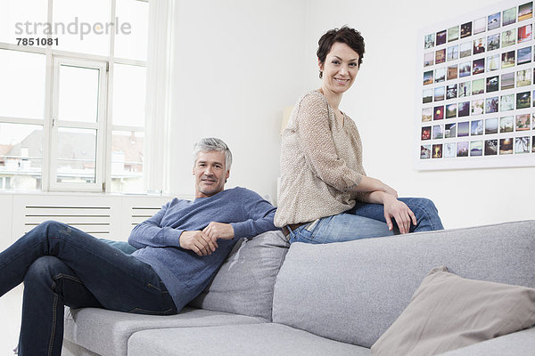 Deutschland  Bayern  München  Paar auf Sofa sitzend  lächelnd