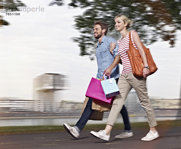 Junge Frau und mittelgroßer Mann mit Einkaufstaschen
