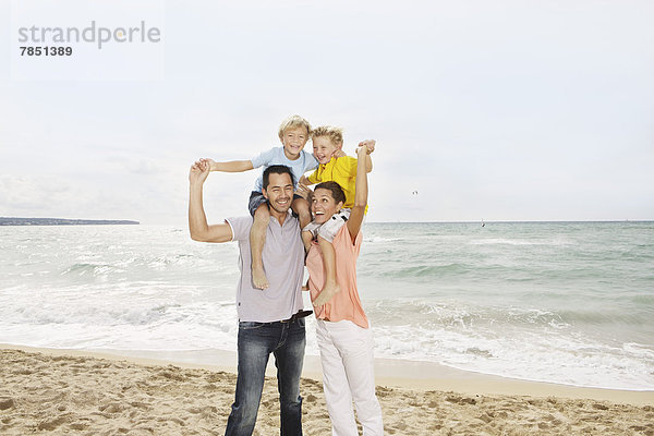 Spanien  Familie am Strand von Palma de Mallorca  lächelnd