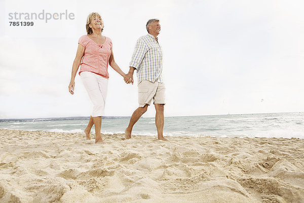 Spanien  Seniorenpaar zu Fuß am Strand von Palma de Mallorca
