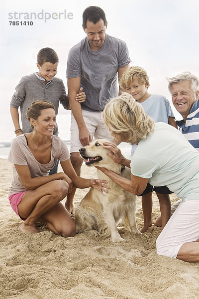 Spanien  Familie mit Hund am Strand von Palma de Mallorca  lächelnd