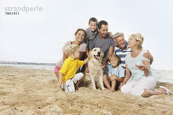 Spanien  Familie am Strand von Palma de Mallorca sitzend  lächelnd