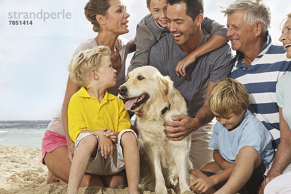 Spanien  Familie am Strand von Palma de Mallorca sitzend  lächelnd