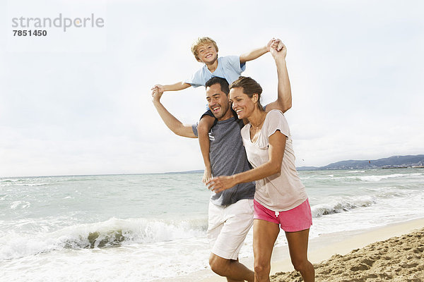 Spanien  Familienspaziergang am Strand von Palma de Mallorca  lachend