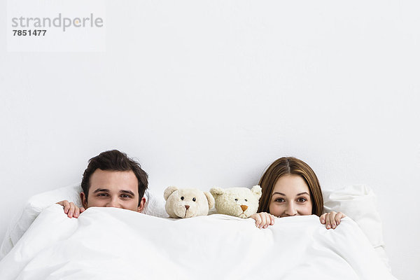 Porträt eines jungen Paares mit Teddybär  lächelnd