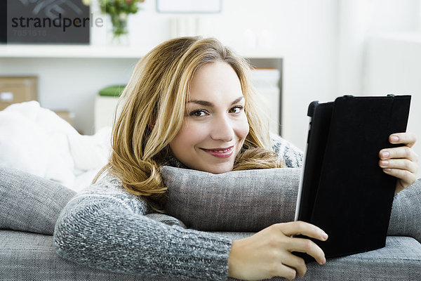 Porträt einer jungen Frau mit digitalem Tablett  lächelnd