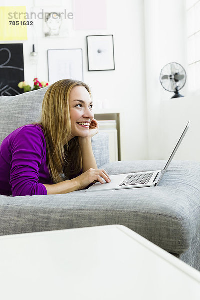 Junge Frau mit Laptop  lächelnd