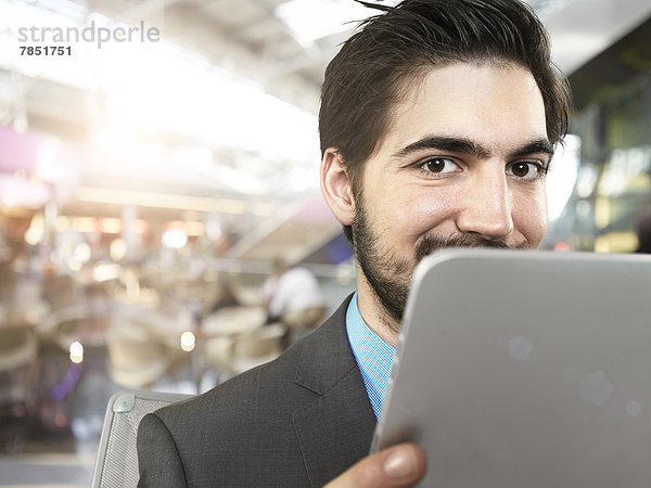 Porträt eines jungen Geschäftsmannes mit digitalem Tablett  lächelnd