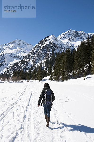 Österreich  Frau beim Wandern in den Tannheimer Alpen im Winter