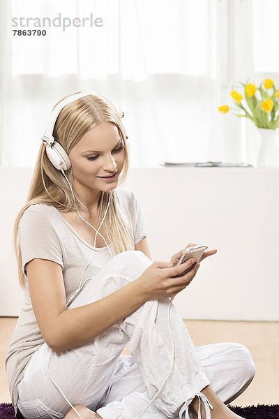 Interior  zu Hause  blond  Frau  Kopfhörer  jung  Smartphone
